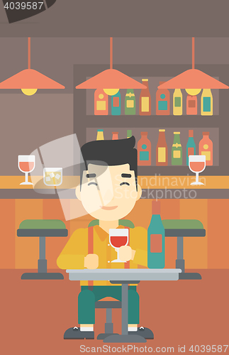 Image of Man drinking wine at restaurant.