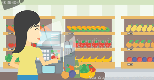 Image of Cashier standing at the checkout in supermarket.