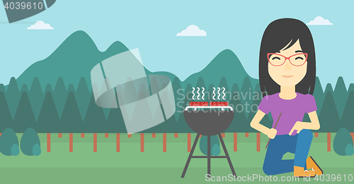 Image of Woman cooking meat on barbecue.