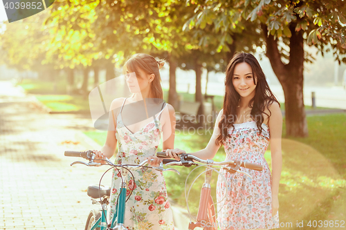 Image of The two young girls with bicycles in park