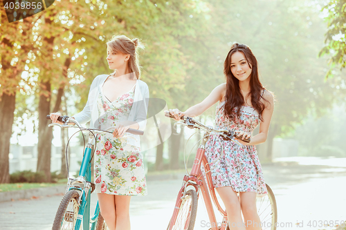Image of The two young girls with bicycles in park