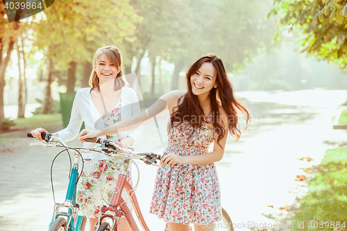 Image of The two young girls with bicycles in park