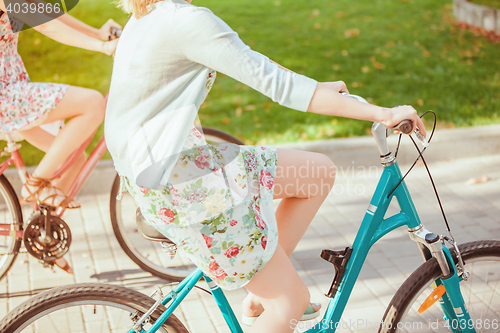 Image of The two young girls with bicycles in park
