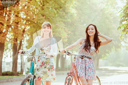 Image of The two young girls with bicycles in park