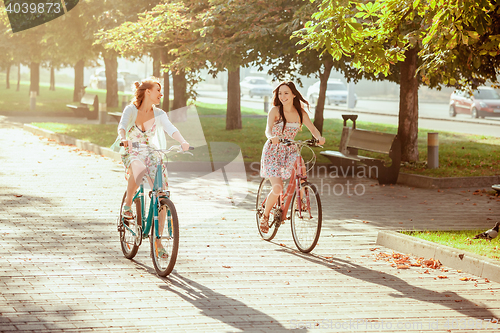 Image of The two young girls with bicycles in park