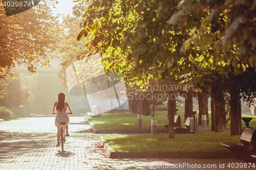 Image of The young girl with bicycle in park