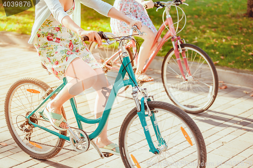 Image of The two young girls with bicycles in park