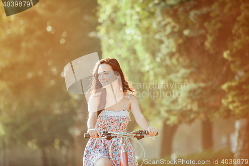 Image of The young girl with bicycle in park