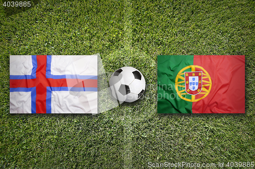 Image of Faroe islands vs. Portugal flags on soccer field