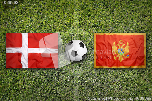 Image of Denmark vs. Montenegro flags on soccer field