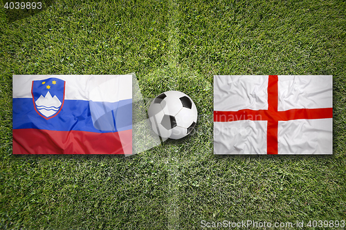 Image of Slovenia vs. England flags on soccer field