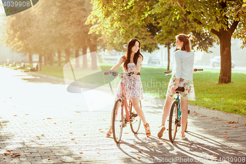 Image of The two young girls with bicycles in park