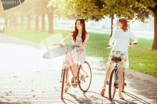 Image of The two young girls with bicycles in park