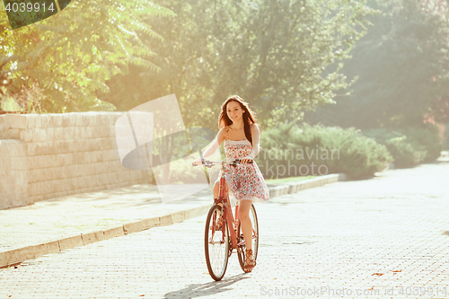 Image of The young girl with bicycle in park