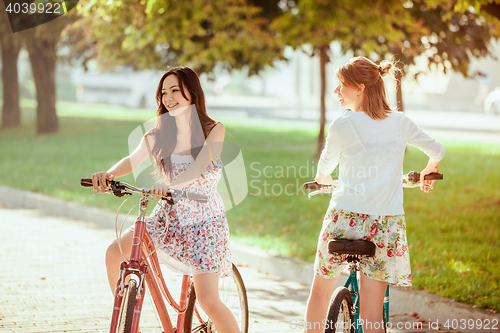 Image of The two young girls with bicycles in park