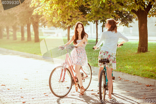 Image of The two young girls with bicycles in park