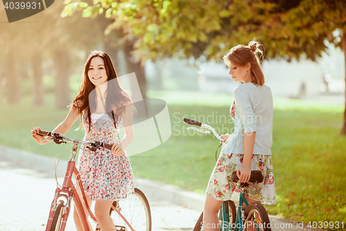 Image of The two young girls with bicycles in park