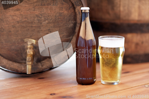 Image of close up of old beer barrel, glass and bottle