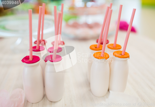 Image of close up of bottles with drinks and straws