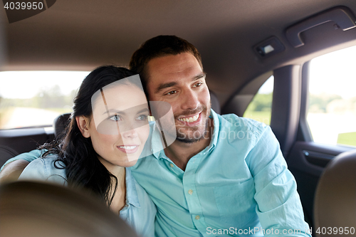 Image of happy man and woman hugging in car