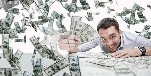 Image of happy businessman with heap of money