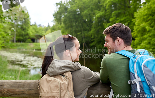 Image of smiling couple with backpacks in nature