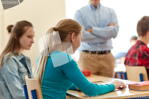 Image of sad student girl with test result and teacher