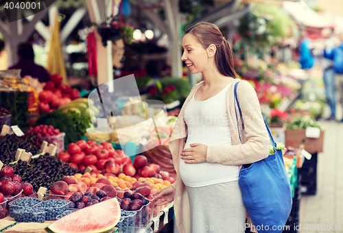 Image of pregnant woman choosing food at street market