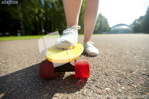 Image of close up of female feet riding short skateboard