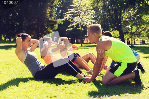 Image of group of friends or sportsmen exercising outdoors