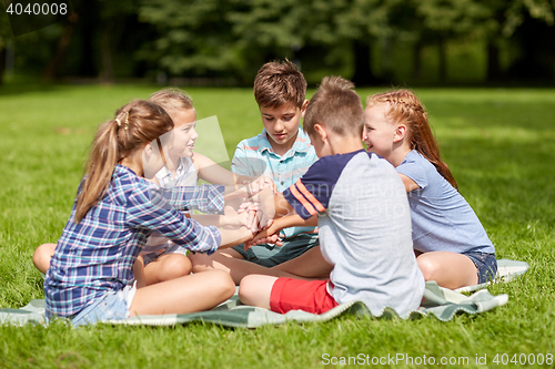 Image of group of happy kids putting hands together