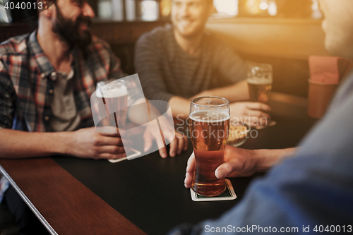 Image of happy male friends drinking beer at bar or pub