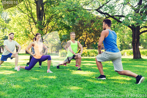 Image of group of friends or sportsmen exercising outdoors