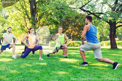 Image of group of friends or sportsmen exercising outdoors