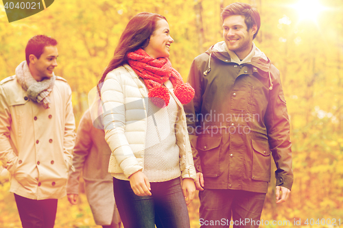 Image of group of smiling men and women in autumn park