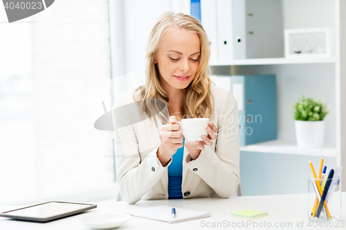 Image of happy businesswoman drinking coffee at office