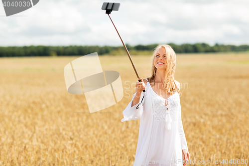 Image of happy young woman taking selfie by smartphone