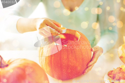 Image of close up of woman with pumpkins at home