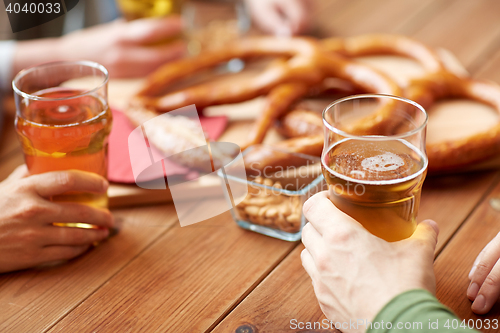 Image of close up of men drinking beer with pretzels at pub