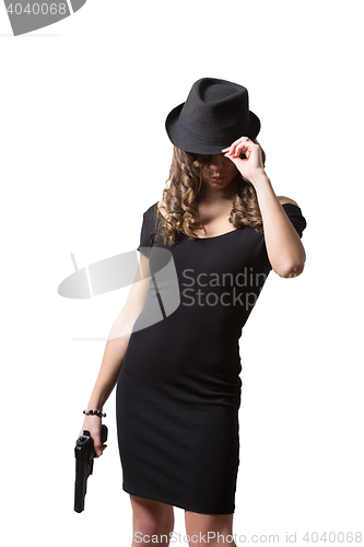 Image of beautiful girl in evening dress and hat holding gun. Isolated on white background