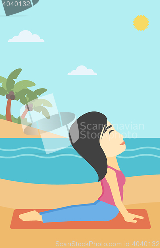 Image of Woman practicing yoga upward dog pose on beach.