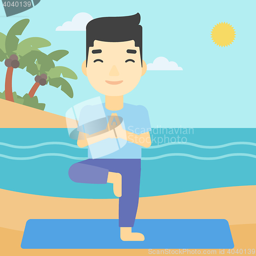 Image of Man practicing yoga tree pose on the beach.