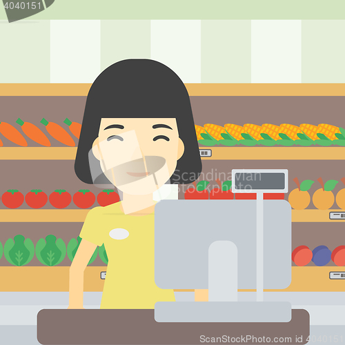 Image of Cashier standing at the checkout in supermarket.