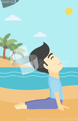 Image of Man practicing yoga upward dog pose on the beach.