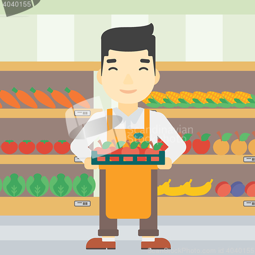 Image of Supermarket worker with box full of apples.