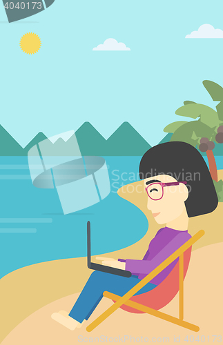 Image of Business woman working on laptop on the beach.
