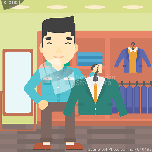 Image of Man holding suit jacket in clothing store.
