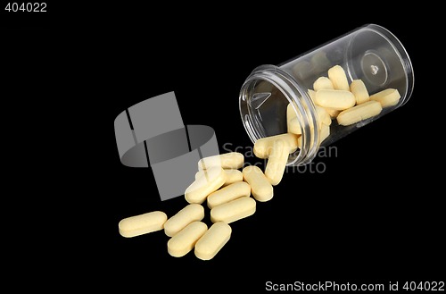 Image of Yellow pills spilling out of a bottle