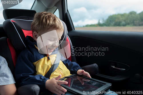 Image of Happy boy playing with touchpad in the car