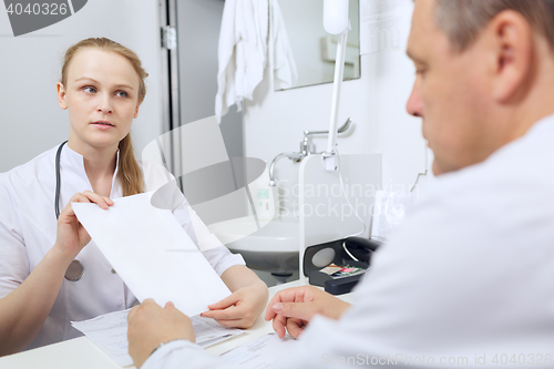 Image of Nurse shows to the doctor blank sheet of paper